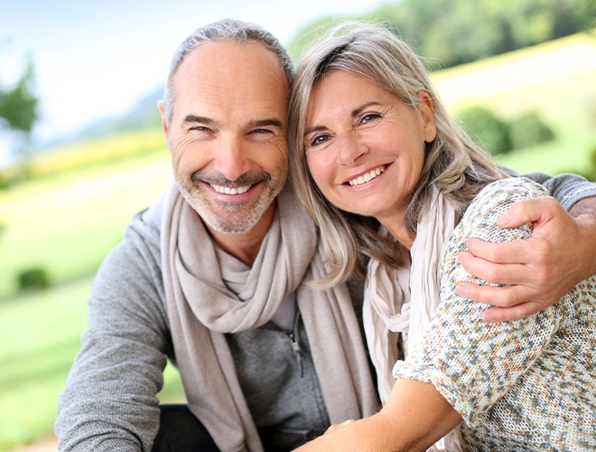 Older man and woman with beautiful smiles thanks to cosmetic dentistry