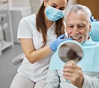 An older man happy with his new dental implant