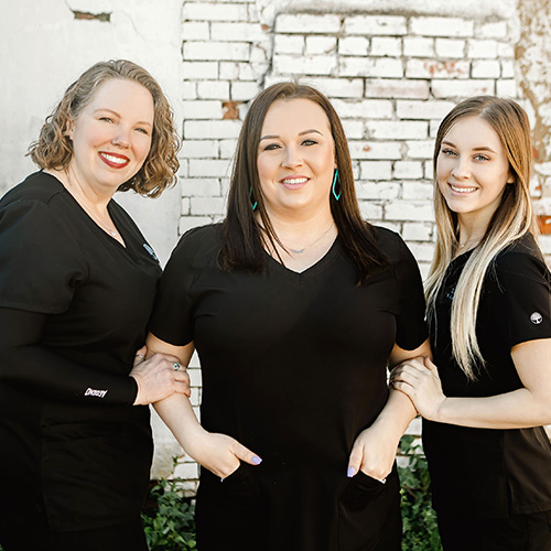 Three friendly smiling dental team members