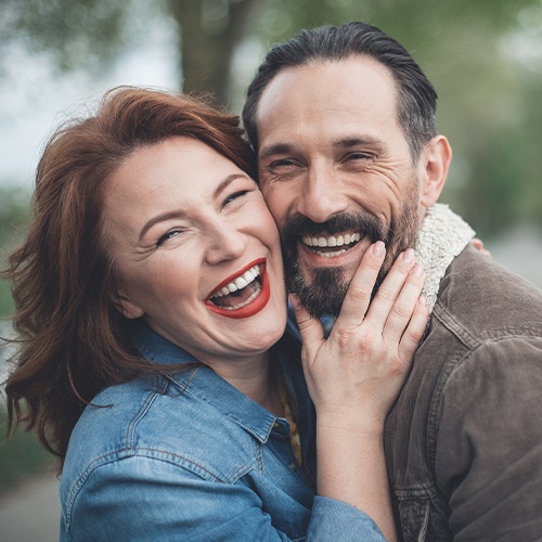 Older man and woman smiling after amalgam filling removal