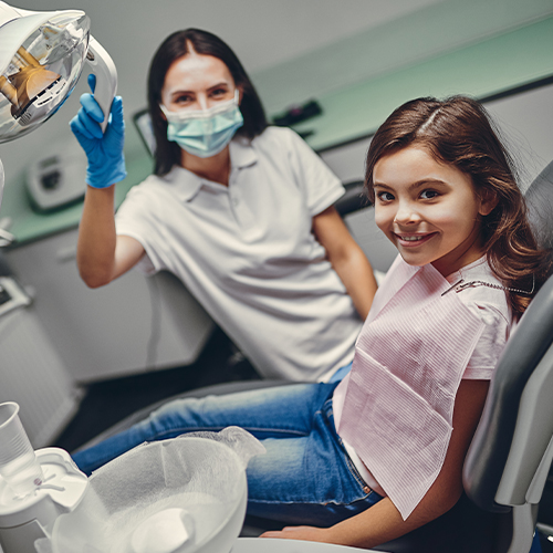 Girl in dental office smiling after pulp therapy