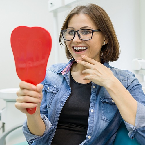 Woman looking at her beautiful smile makeover