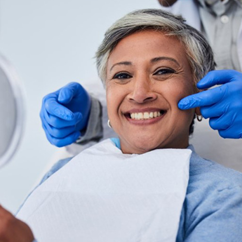 Middle-aged woman smiling after receiving a dental crown in Midlothian 