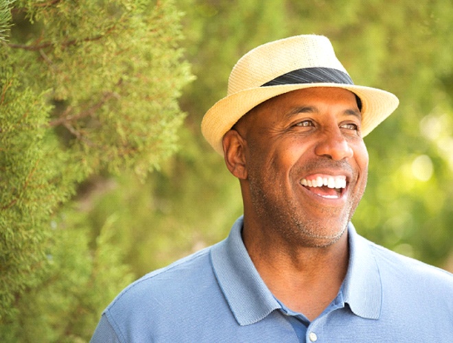 man with a dental bridge in Midlothian standing among trees