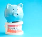 Piggy bank resting on a model of teeth