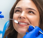 A young female smiling as her dentist prepares to examine her smile in Midlothian