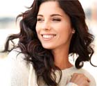 Woman in sweater smiling with dental implants in Midlothian, TX