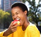 Woman with dental implants in Midlothian, TX eating an apple