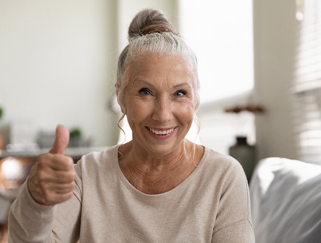 woman smiling and giving thumbs up