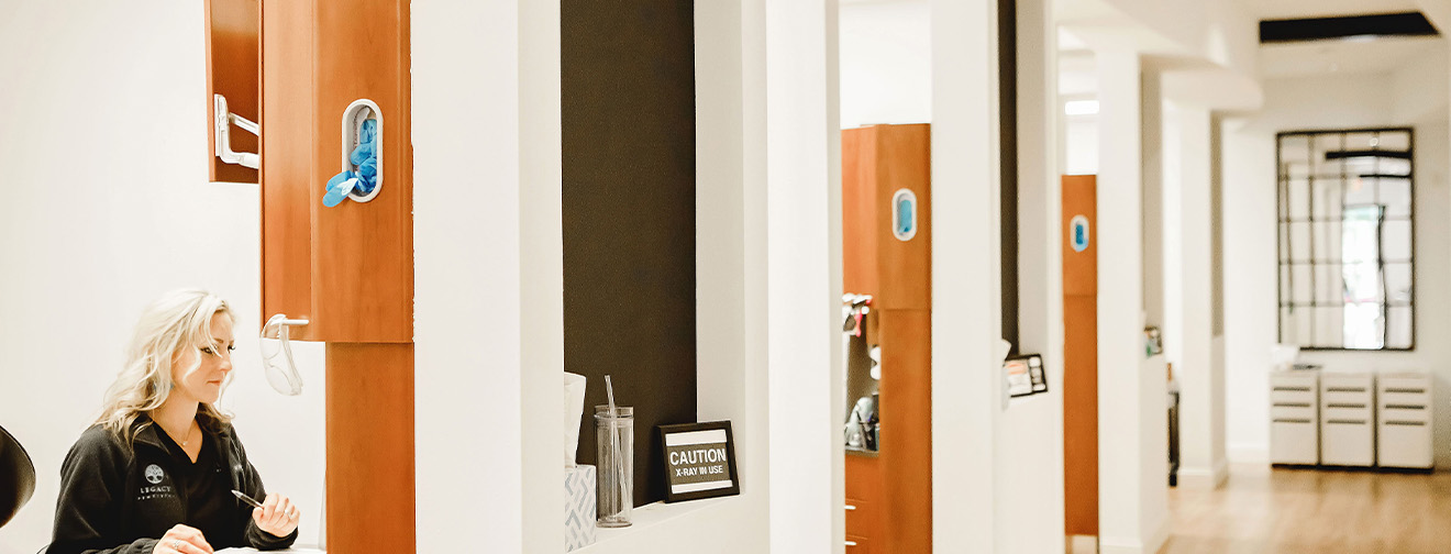 Hallway in Midlothian dental office looking into treatment room with dental team member working