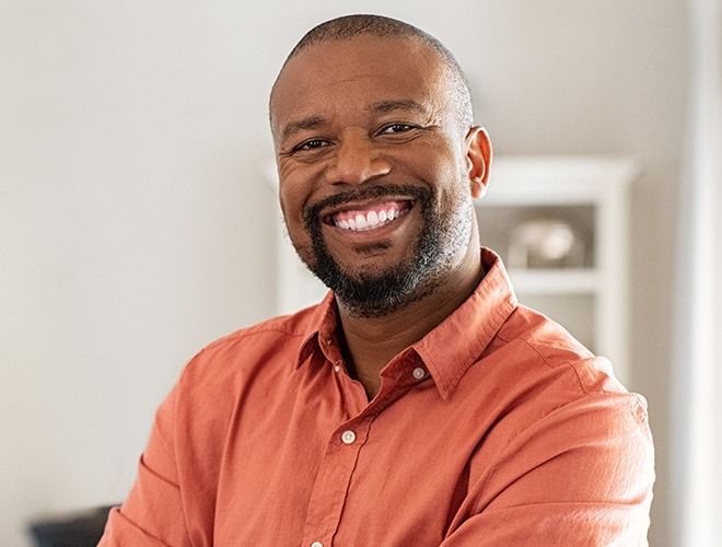 Man sharing flawless smile after replacing missing teeth