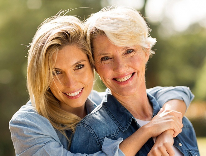 Mother and adult daughter with healthy smiles after periodontal therapy