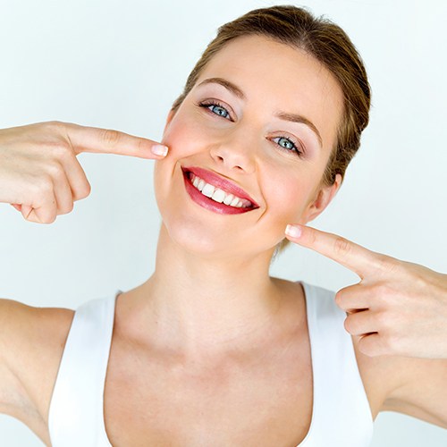 Patient pointing to smile after scaling and root planing