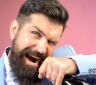 Man opening wine bottle with teeth