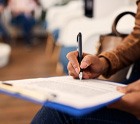 Woman filling out dental insurance form in lobby