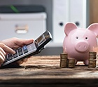 Calculator is used near piggy bank