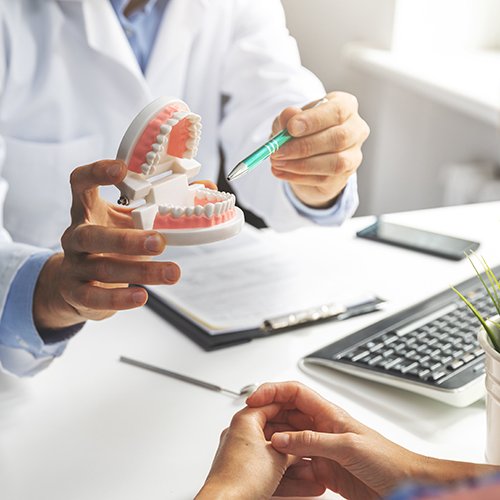 Patient pointing to model of teeth