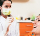 Patient smiling as dentist holds their extracted wisdom tooth