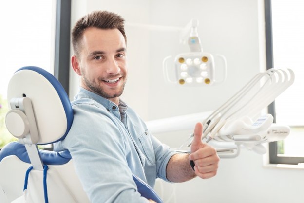 Man giving a thumb's up at the dentist's office.