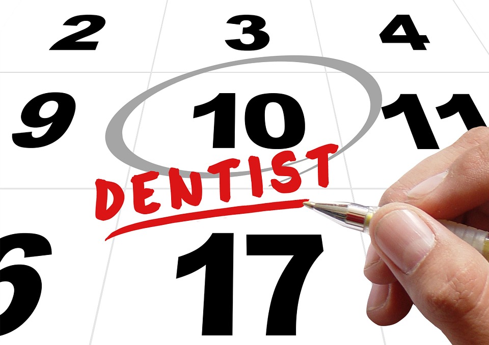 calendar with reminder to visit dentist and toothbrush