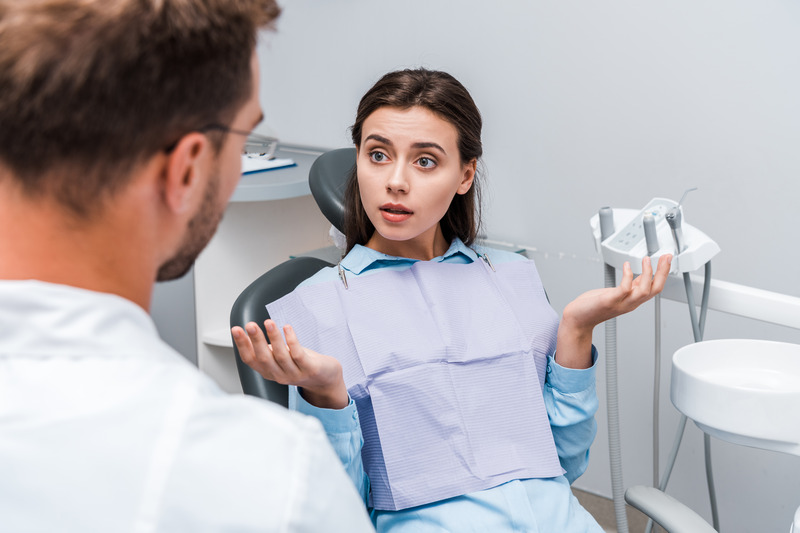 Patient shrugging at dentist after wisdom teeth extraction